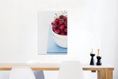 Gros plan d'un bol rempli de cerises sur fond bleu Toile 40x60 cm - Tirage photo sur toile (Décoration murale salon / chambre)
