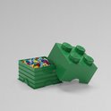 Groene LEGO opbergdoos met deksel, gevuld met veelkleurige LEGO-stenen. De deksel is een grote groene LEGO-steen met vier noppen.