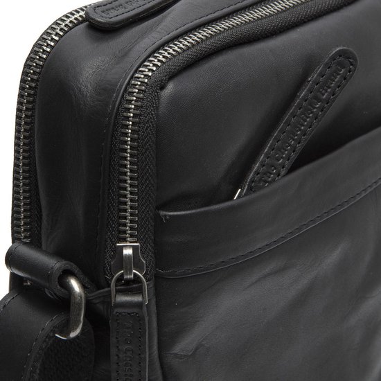 Detail van de dubbele rits en een steekvak van een zwarte leren tas.