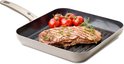 Grijze grillpan met bruine steel, gegrilde steak en takjes tijm.