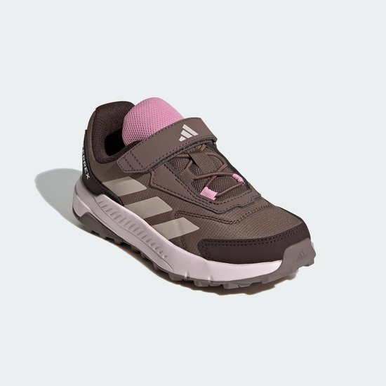 Bruine Terrex sportschoen met roze accenten, beige strepen en klittenbandsluiting.