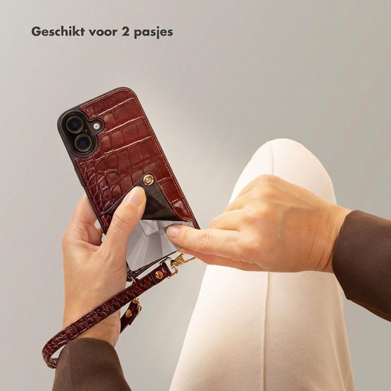 Handen tonen de bordeauxrode croco backcover met een pashouder aan de achterkant, en een polsband.
