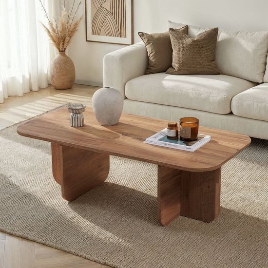 Salontafel met houten nerfprint, afgeronde hoeken, in een woonkamer met bank, kussen en decoraties.