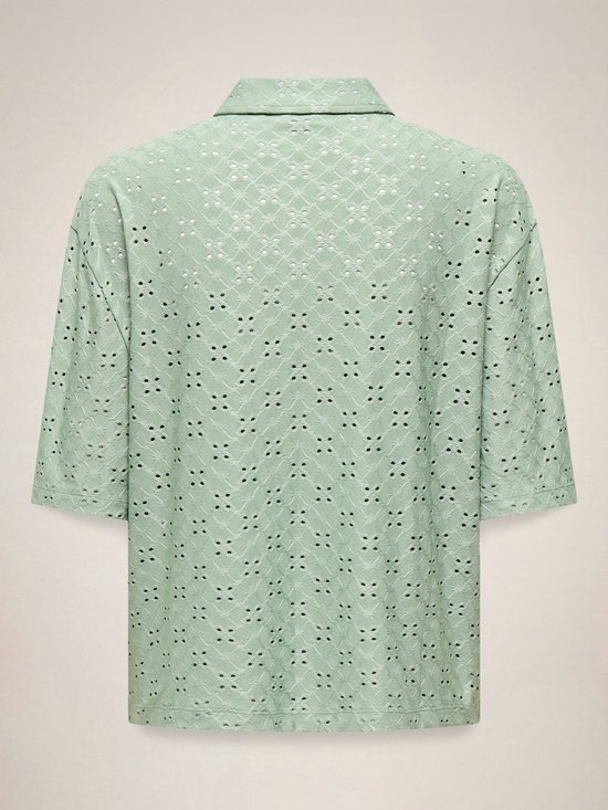 Achterkant van een lichtgroene blouse met broderie anglaise, korte mouwen en een kraagje.