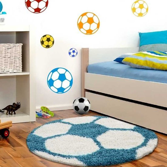 Tapis rond design football bleu turquoise et blanc, avec des stickers assortis sur le mur.
