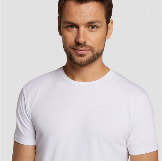 Man met korte bruine baard, draagt wit t-shirt.
