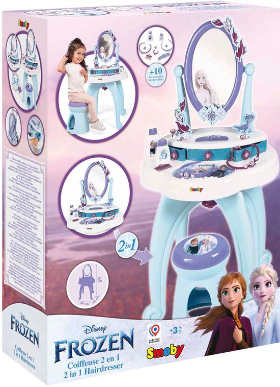 De verpakking van een Smoby Frozen speelgoedkaptafel. Toont de kaptafel, een meisje, de '2-in-1' functie en afmetingen.