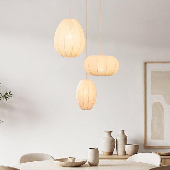 Drie beige hanglampen in verschillende maten en vormen, met stoffen kappen en een roze ondertoon.