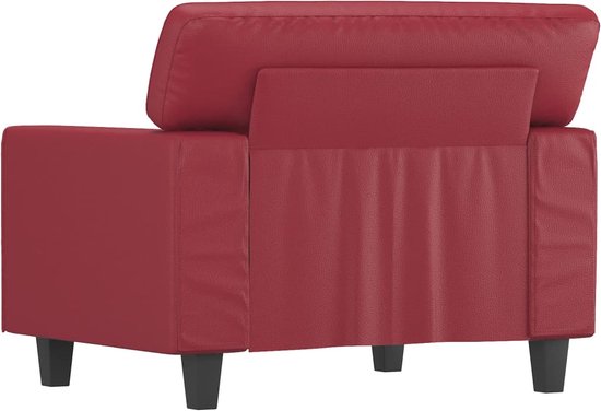 Achterkant van een wijnrode kunstleren fauteuil op korte, zwarte pootjes.