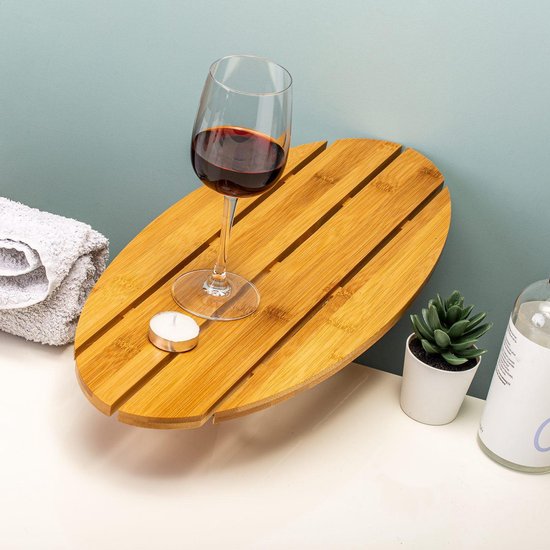 Plateau de bain en bois avec verre de vin rouge, bougie, plante et serviette.