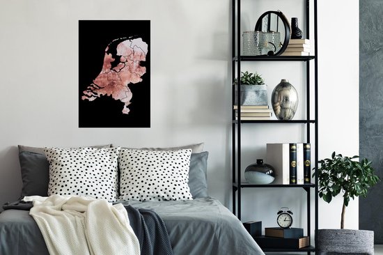 Affiche des Pays-Bas en teintes rose délavé avec bordure noire, suspendue à un mur au-dessus d'un lit.