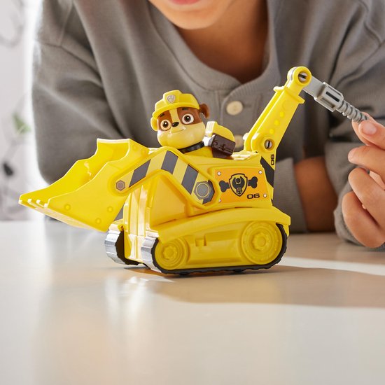 Een jongen speelt met een gele Paw Patrol bulldozer waarin Rubble zit.