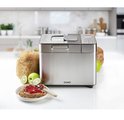 RVS broodmachine met brood en toast met jam in een keukenomgeving.