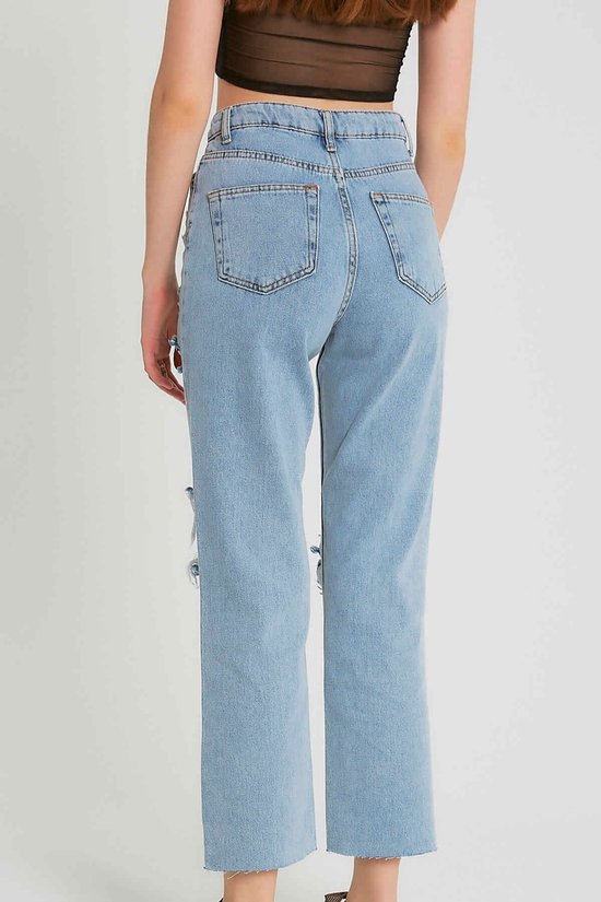 Achterkant van een model in een spijkerbroek met hoge taille, lichtblauw en gescheurd, met wijde pijpen.