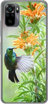 Geschikt voor Xiaomi Redmi Note 10 hoesje - Close-up van een kleurrijke vogel naast planten met oranje bloemen - Siliconen Telefoonhoesje