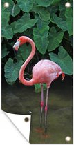 Wanddecoratie buiten Een flamingo staat in het ondiepe water - 80x160 cm - Tuindoek - Buitenposter