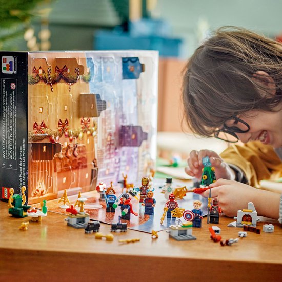 Jongen speelt met LEGO Marvel Avengers Adventskalender figuren waaronder Spider-Man, Iron Man en Captain America.