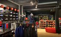 Winkelinterieur met rekken vol basketbaltenues, sportkleding en basketballen.