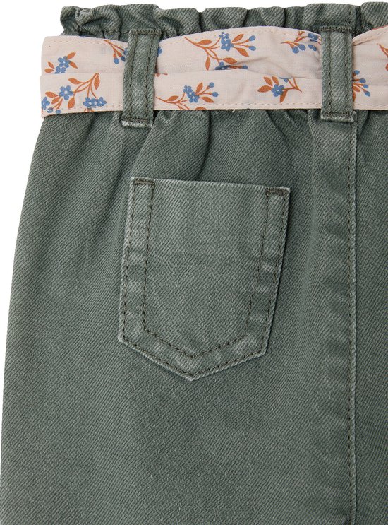 Detail van de achterzak van een olijfgroene broek met een bloemige riem in een roze tint.