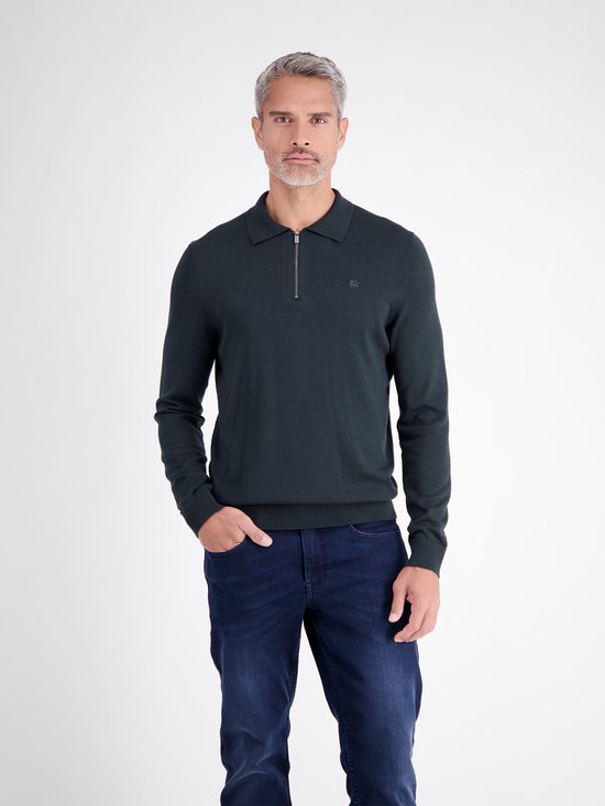 Man met grijze haren draagt donkerblauw poloshirt met ritssluiting, geborduurd logo en jeans.