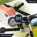 Hand wordt getoond die handvatten vastpakt. 2-in-1 fietskar/handkar. Aansluiting aan fiets.