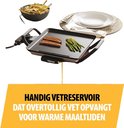 Tristar grillplaat met worstjes en asperges, met een bakje friet en een stapel borden ernaast.