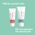 Twee tubes Naïf babyverzorging op mintgroene achtergrond. Rechts: 2-in-1 Shampoo Body Wash. Links: Baby Cream.
