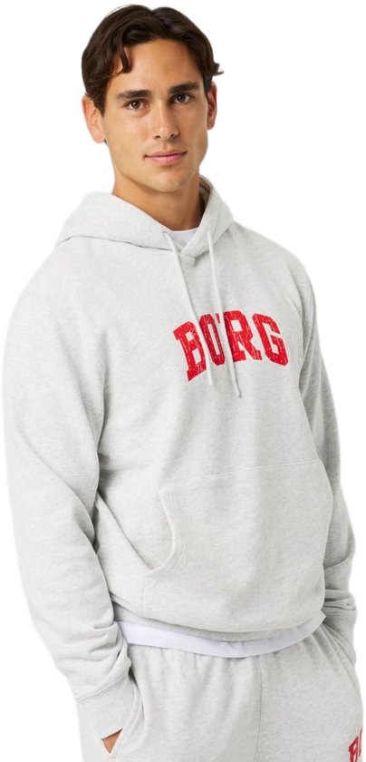Lichtgrijze hoodie met rode 'BORG' tekst, gedragen door een man met een hand in de zak.