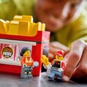 Twee LEGO-poppetjes bij een snackwagen met "FRIES"-logo.