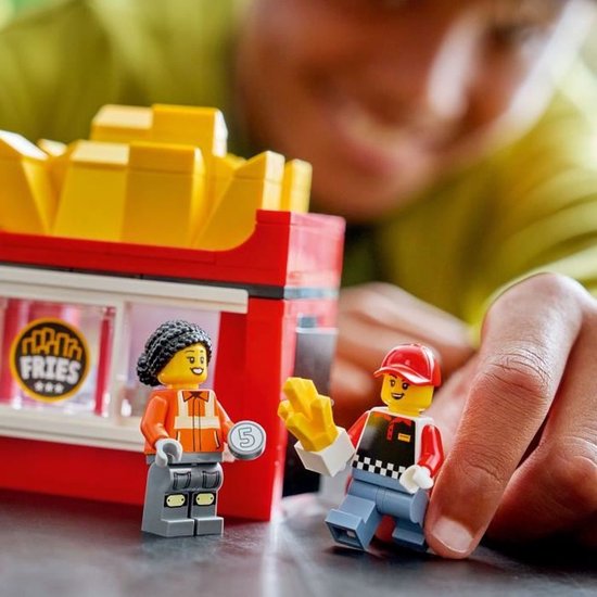 Twee LEGO-poppetjes bij een snackwagen met "FRIES"-logo.