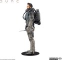 Dune actiefiguur van opzij, met baard, grijze tactische uitrusting, rugzak en een vasthoudend mes.
