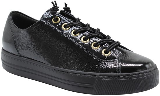 Schuin van voren gezien, een zwarte lakleren Paul Green sneaker met gouden veterringen.