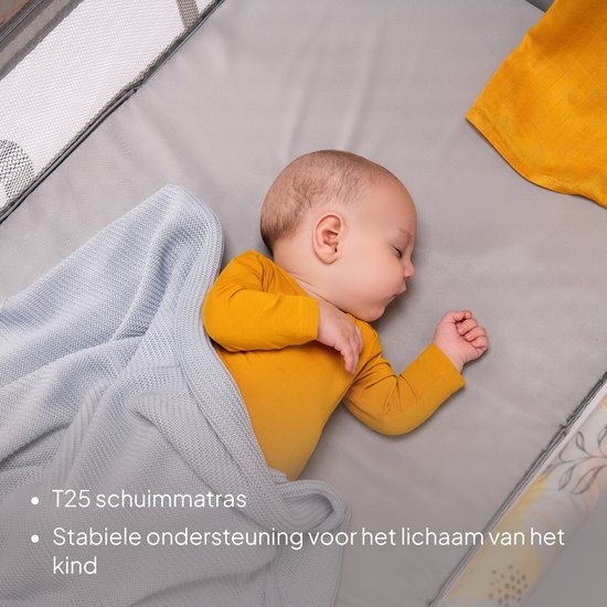Baby slaapt in een reisbedje op een T25 schuimmatras, onder een blauwe deken, met stabiele lichaamssteun.