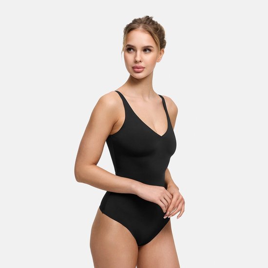 Model draagt een nauwsluitende zwarte stringbody met een diepe V-hals.