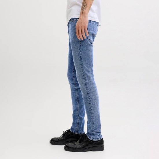 Blauwe slim fit jeans met lichte wassing, gedragen door een man.