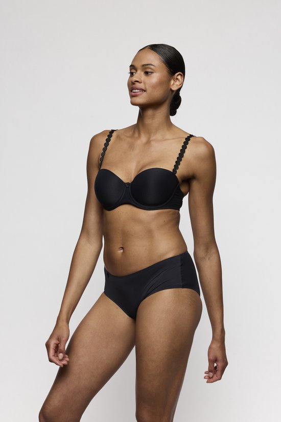 Model in zwart strapless lingerieset met de cup van de bh zichtbaar.