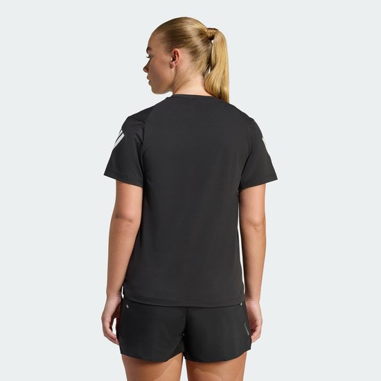 Achterkant vrouw in zwart sportshirt met witte Adidas strepen op de mouwen.