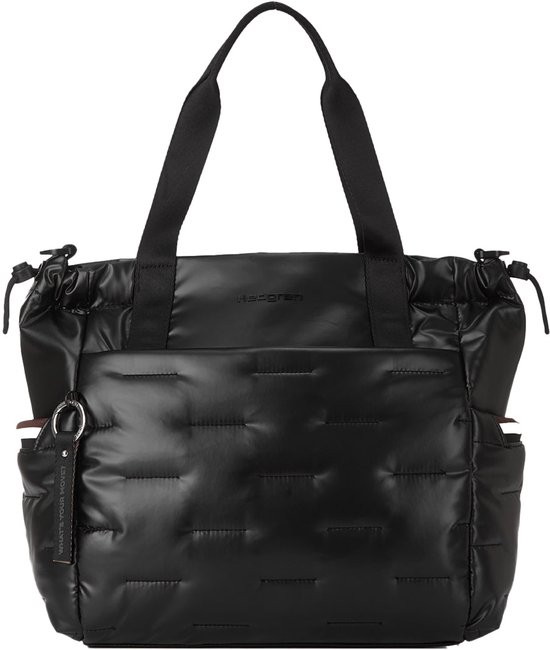 Zwarte gewatteerde shopper met Hedgren-logo, een buitenvak, zijvakken en een sleutelhanger met tekst.