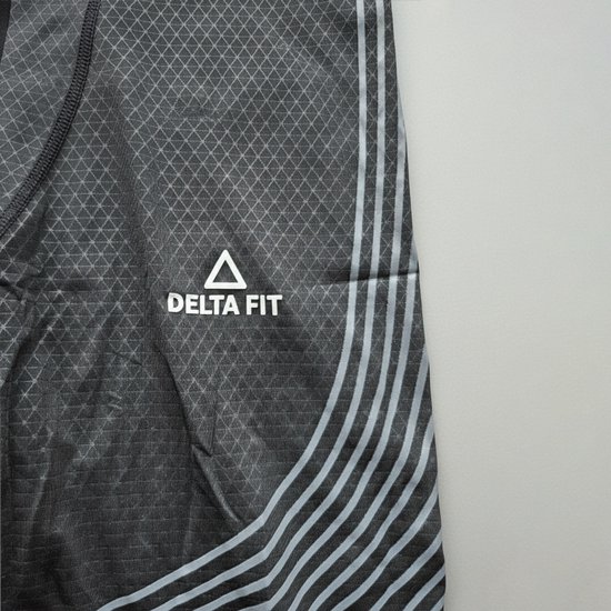 Detail van de zwarte legging met ruitpatroon, gebogen grijze lijnen en het Delta Fit logo.