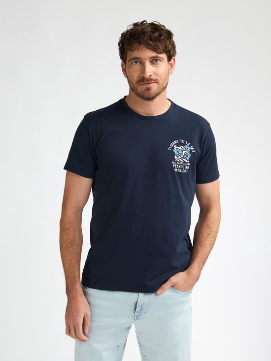 Man met donkerblauw T-shirt met kleine grafische print op de borst.