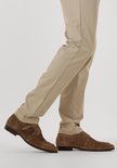 Een man draagt bruine suède monk strap schoenen met beige broek.