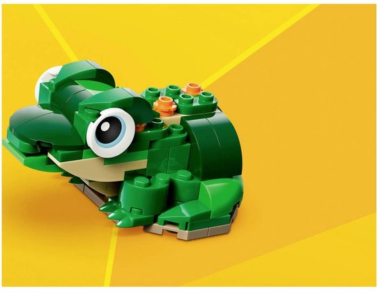 Een groene legokikker met grote ogen en oranje details op zijn rug, zittend op een gele achtergrond.
