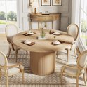 Ronde eettafel met houten visgraatblad en gecanneleerde poot, gedekt met placemats, servies en glazen.
