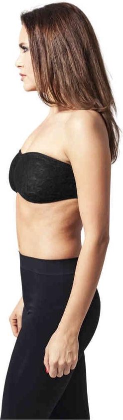 Zijaanzicht van model in zwarte kanten bandeau top en zwarte legging.