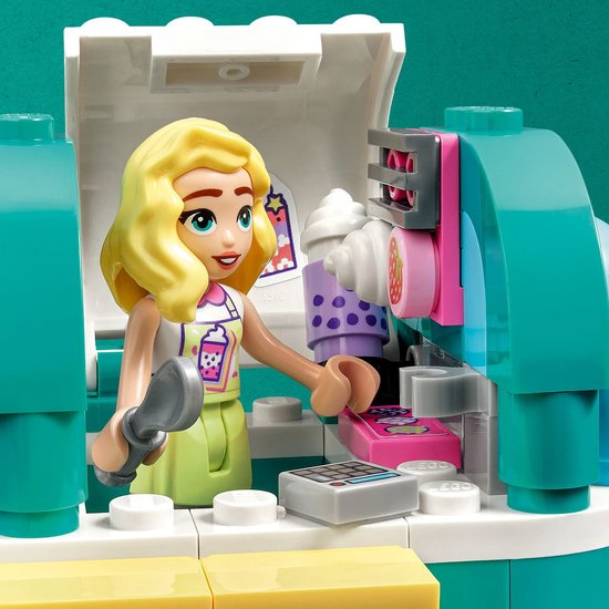 LEGO Friends pop met blond haar, in mintgroen jurkje, in de mintgroene en gele mobiele bubbelthee stand.