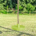 Groene schijfschommel met touw in een tuin, met de onderkant van het klimtoestel op de achtergrond.
