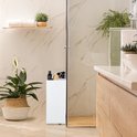 Witte opbergkast met wieltjes in een moderne badkamer met planten en marmeren tegels.