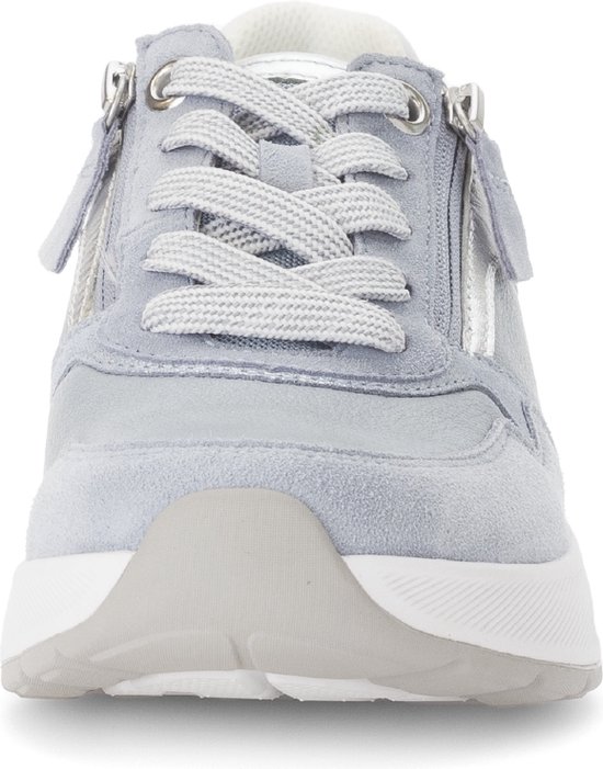 Voorkant van lichtblauwe sneaker met zilveren details en ritssluiting.