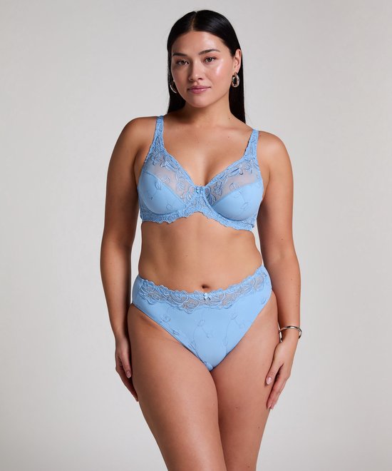 Model draagt een lichtblauwe beugelbeha met bloemenkant en bijpassende slip.