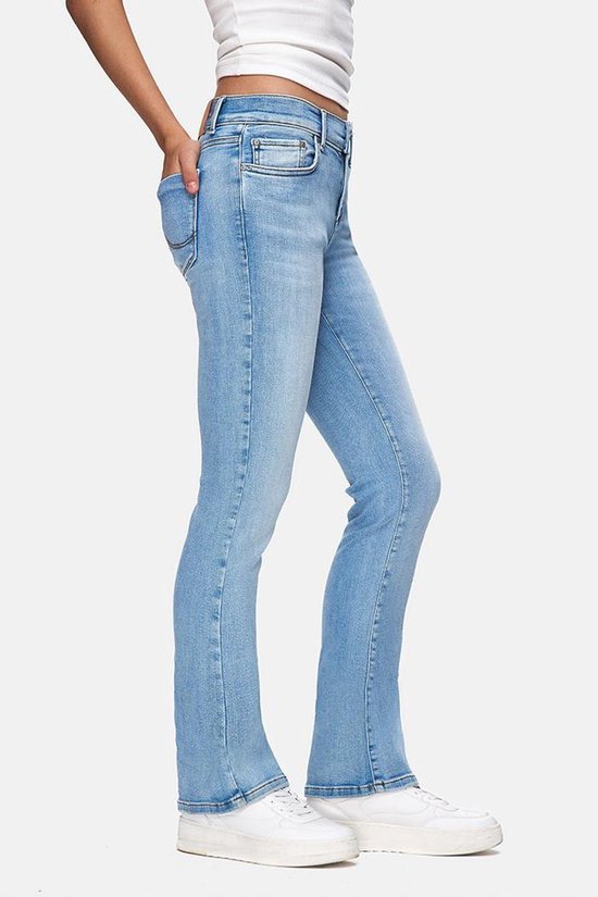 Zijzicht van een model in een witte tanktop en lichtblauwe flared jeans.
